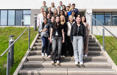 Gruppenfoto mit 22 Auszubildenden und einer Lehrerin. Die Gruppe steht auf der Treppe vor dem Verwaltungsgebäude des Evangelischen Krankenhauses Duisburg-Nord.