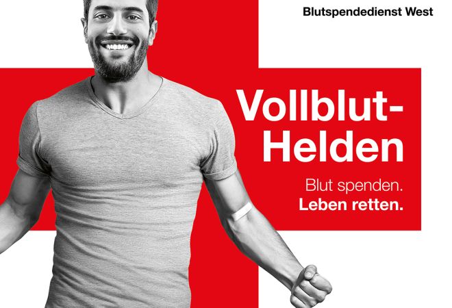 Werbeplakat des DRK-Blutspendedienstes West mit rotem Hintergrund, Rotkreuz-Logo und dem Slogan „Vollblut-Helden – Blut spenden. Leben retten.“ Ein Mann steht mit ausgestreckten Armen im Zentrum.