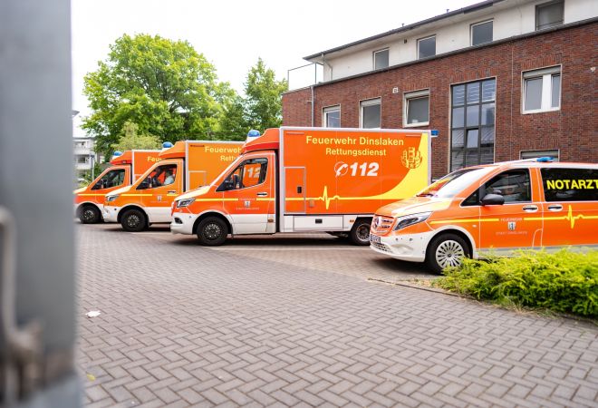Einfahrt zum Evangelischen Krankenhaus Dinslaken. Drei Rettungswagen der Feuerwehr Dinslaken und ein Notarztwagen stehen dort geparkt.