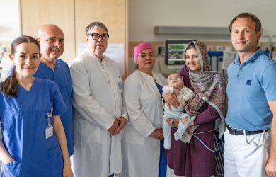 Gruppenfoto auf einer Station im Kimderherzzentrum: Sechs Personen stehen nebeneinander. Von links nach rechts: eine Stationsleiterin, zwei Chefärzte, eine Neurochirurgin, die Mutter mit dem Kind sowie ein Herzchirurg.