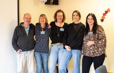 Ein Mitarbeiter und vier Mitarbeiterinnen der Tagespflege Oberhausen Sterkrade stehen nebeneinander, lächeln in die Kamera und posieren gemeinsam für ein Gruppenfoto.