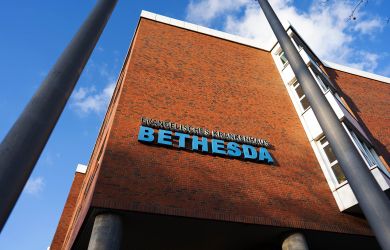 Schriftzug Evangelisches Krankenhaus Bethesda an der Fassade des Krankenhausgebäudes.
