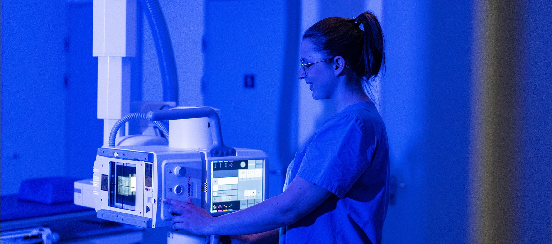 Eine Medizinisch-Technische Radiologieassistentin (MTRA) bedient ein Röntgengerät.