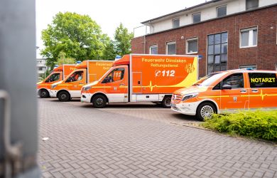Einfahrt zum Evangelischen Krankenhaus Dinslaken. Drei Rettungswagen der Feuerwehr Dinslaken und ein Notarztwagen stehen dort geparkt.