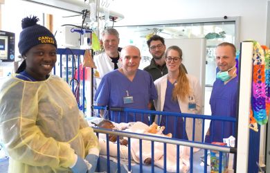 Nana Aba Addae schläft im Krankenbett, umgeben von ihrer Mutter, den Ärzten des Herzzentrums Duisburg und Jens Conrad von der Gerald Asamoah Stiftung.