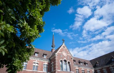 Außenansicht des Johanniter-Krankenhauses Oberhausen: Die Aufnahme zeigt die oberen Etagen des historischen Ziegelbaus mit großen Fenstern und dekorativen Elementen, leicht von unten fotografiert.