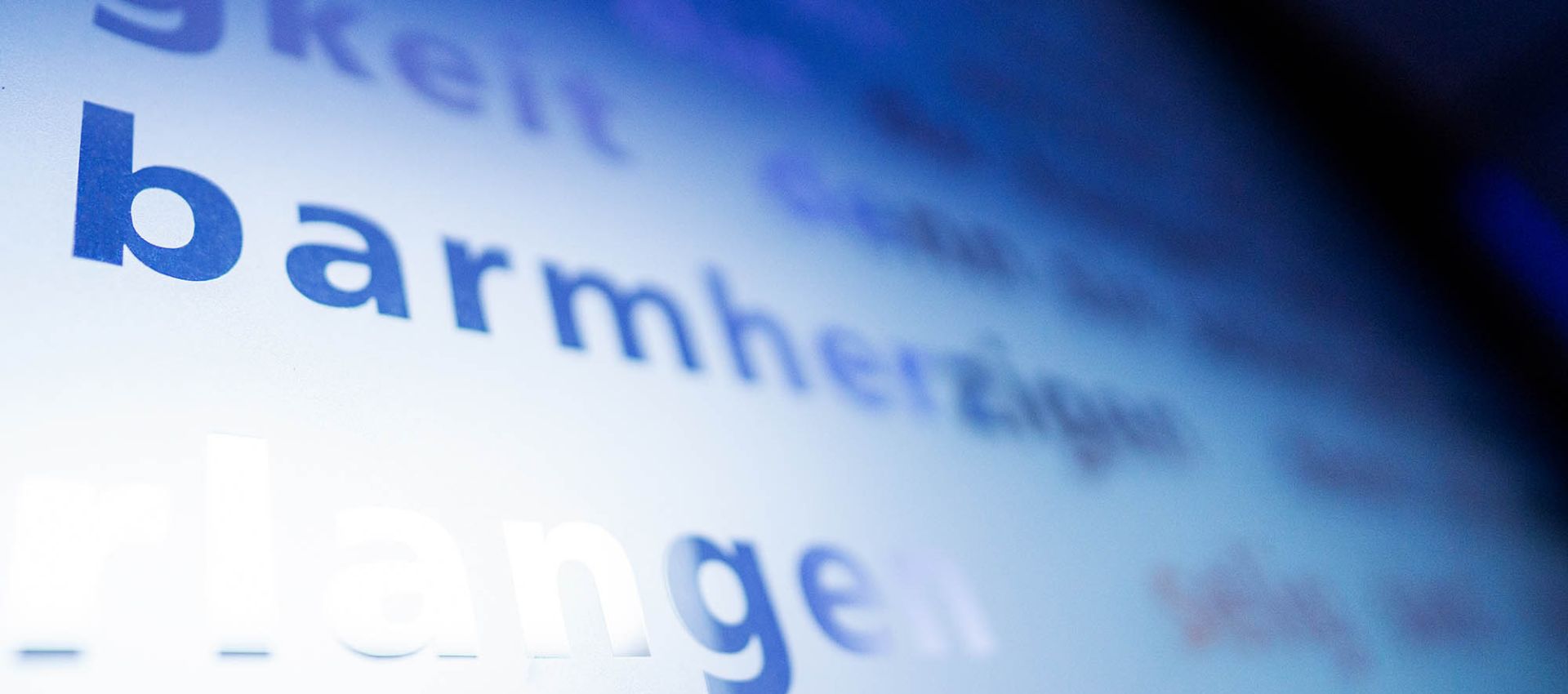 Schriftzug ,barmherzig' an einer Tafel im Raum der Stille.