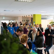 Zahlreiche Besucherinnen und Besucher informieren sich beim Tag der Orthopädie im Evangelischen Krankenhaus Dinslaken. In einem hellen Veranstaltungsbereich führen Gäste, Ärzte und Pflegekräfte Gespräche; im Hintergrund steht ein buntes Glücksrad.