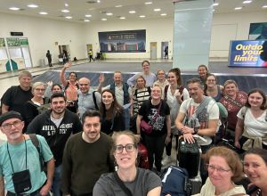 Das Team des Herzzentrums Duisburg ist sicher am Flughafen Accra gelandet und wartet mit Koffern und Taschen am Gepäckband, bevor es weitergeht. Die Gruppe macht ein Selfie.