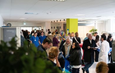 Zahlreiche Besucherinnen und Besucher informieren sich beim Tag der Orthopädie im Evangelischen Krankenhaus Dinslaken. In einem hellen Veranstaltungsbereich führen Gäste, Ärzte und Pflegekräfte Gespräche; im Hintergrund steht ein buntes Glücksrad.