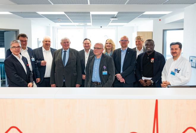 Gruppenfoto auf der Kinderintensivstation: NRW-Gesundheitsminister Karl-Josef Laumann mit den Geschäftsführern des Klinikverbunds EVKLN, Oberbürgermeister Sören Link, Duisburger Politiker:innen, Medizinern sowie Ex-Profi-Fußballer Gerald Asamoah.