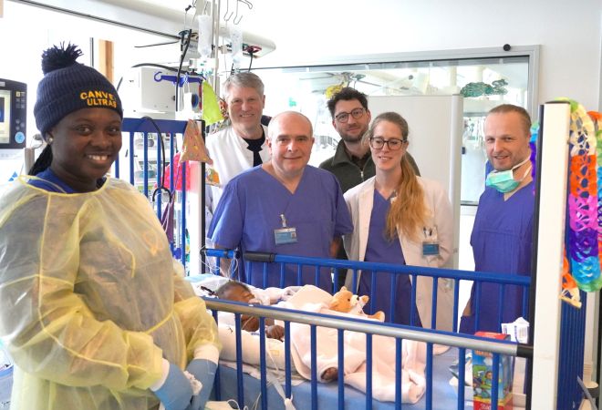 Nana Aba Addae schläft im Krankenbett, umgeben von ihrer Mutter, den Ärzten des Herzzentrums Duisburg und Jens Conrad von der Gerald Asamoah Stiftung.