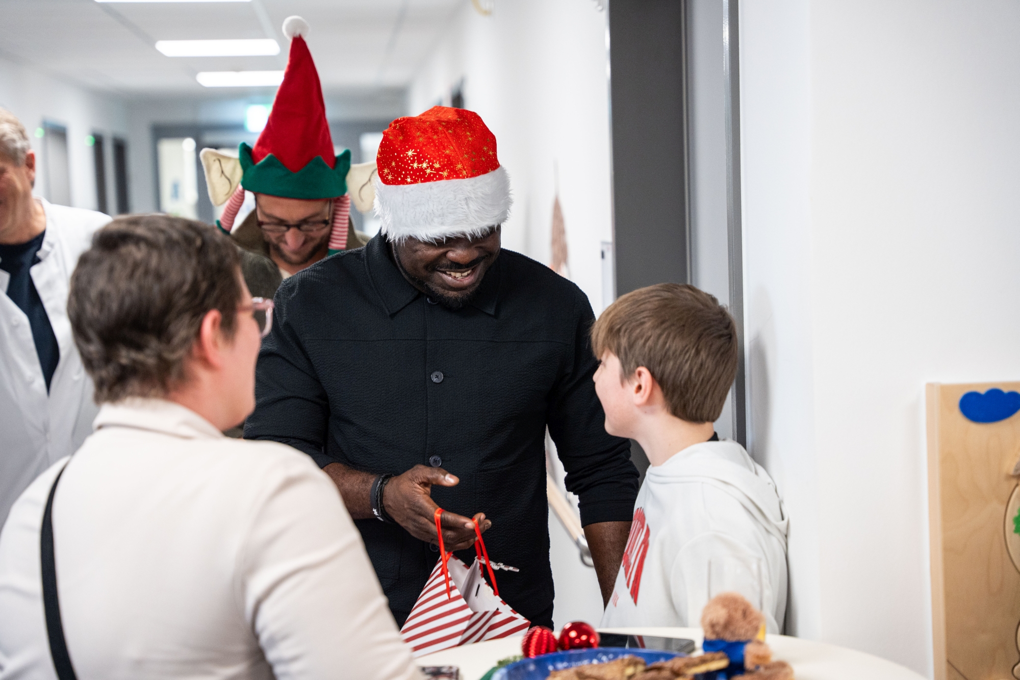 Gerald Asamoah überreicht einem Jungen eine Geschenketüte.